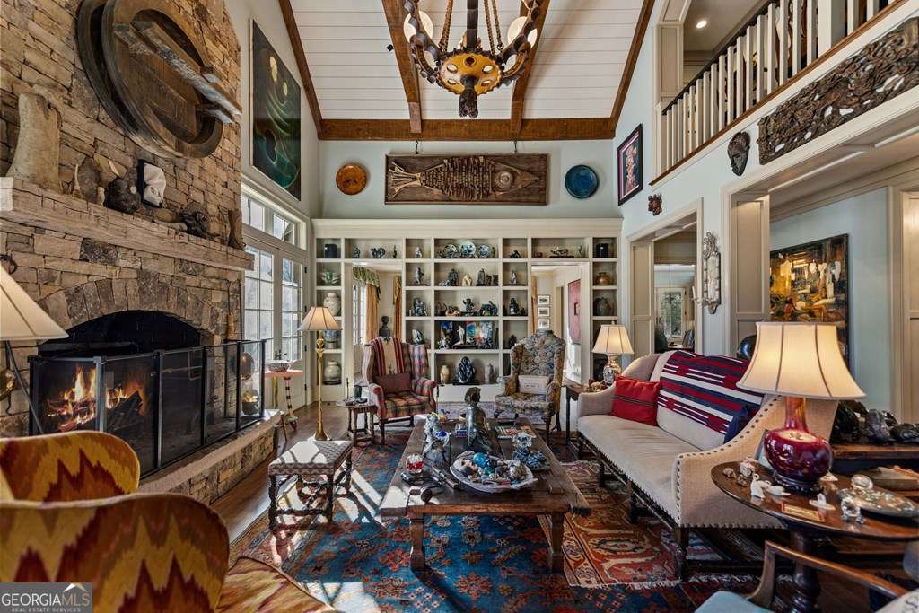 Great room with stone fireplace, tall ceilings and timber details